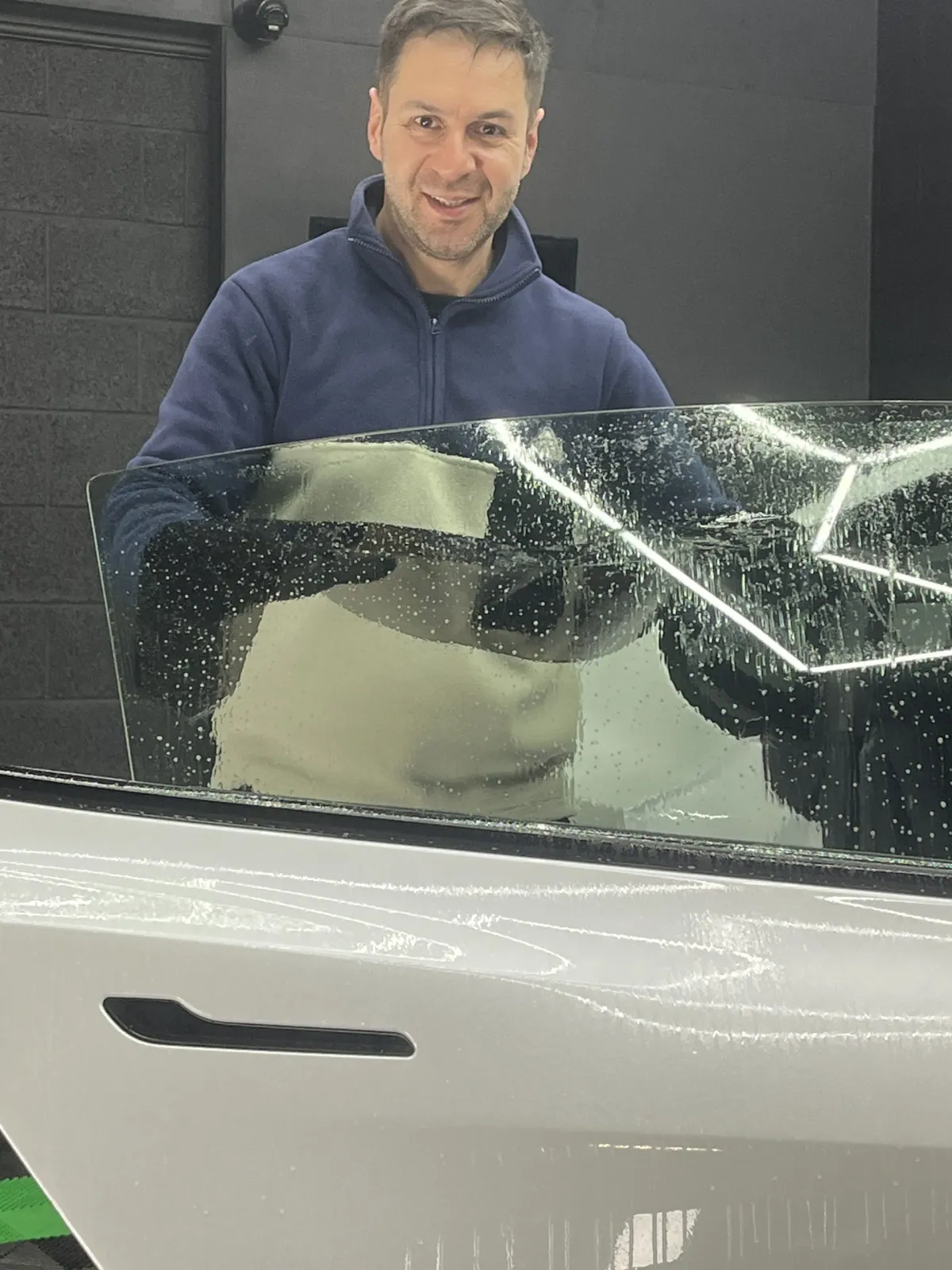 Picture of the owner of Stealth Luxury Detailing, with a black detailing van behind